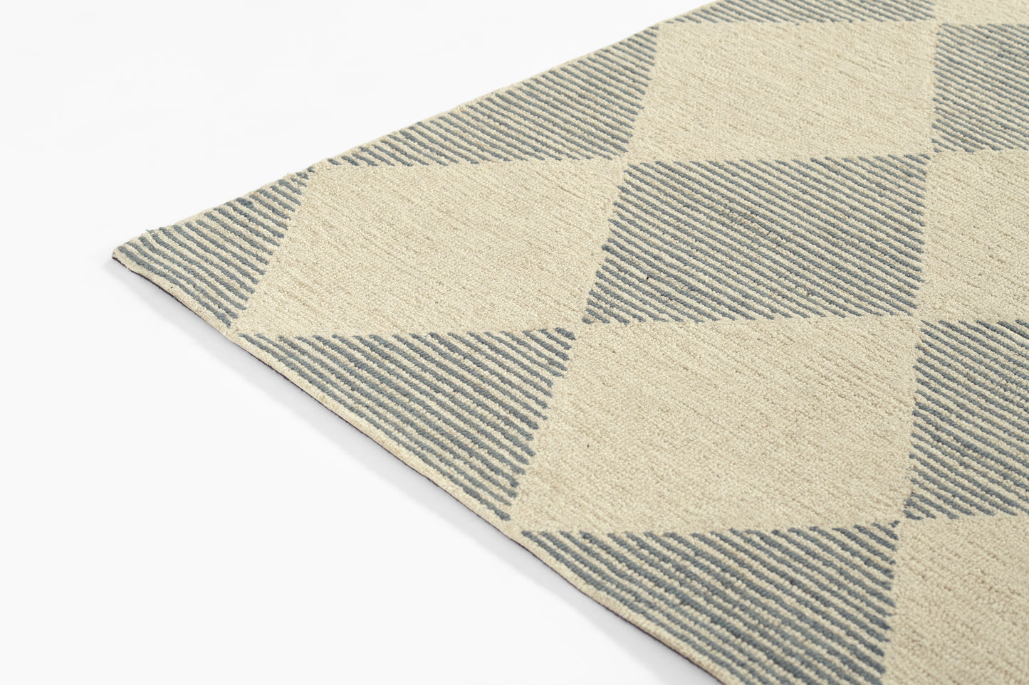 Woven beige and blue argyle diamond rug with striped texture; rectangular accent floor mat.