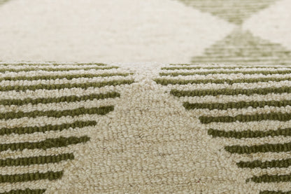 Close-up of beige rug with olive-green geometric chevron pattern and plush textured pile.