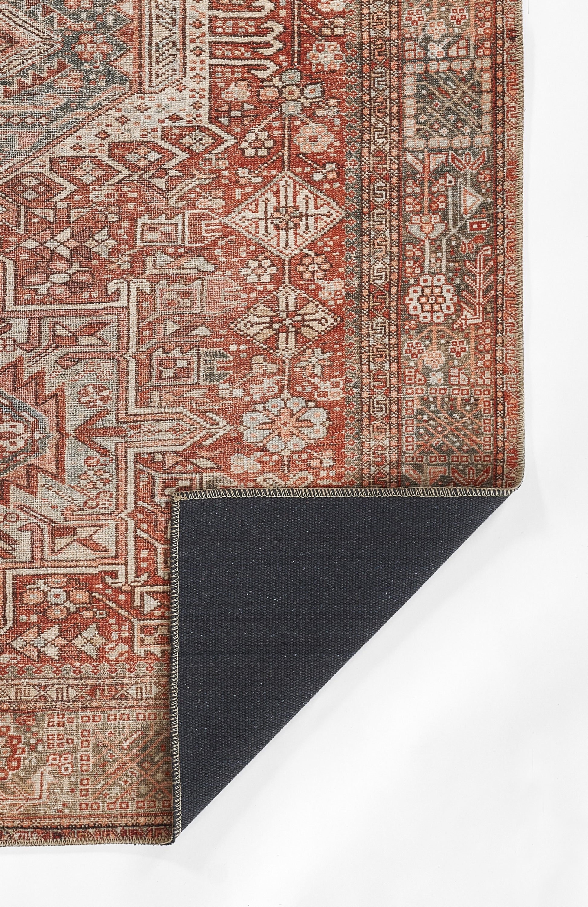 Persian-inspired red vintage rug with ivory geometric motifs and ornate border; navy backing visible at corner.