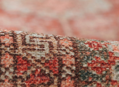 Close-up of red, cream and brown woven rug edge with soft pile and oriental-style pattern.