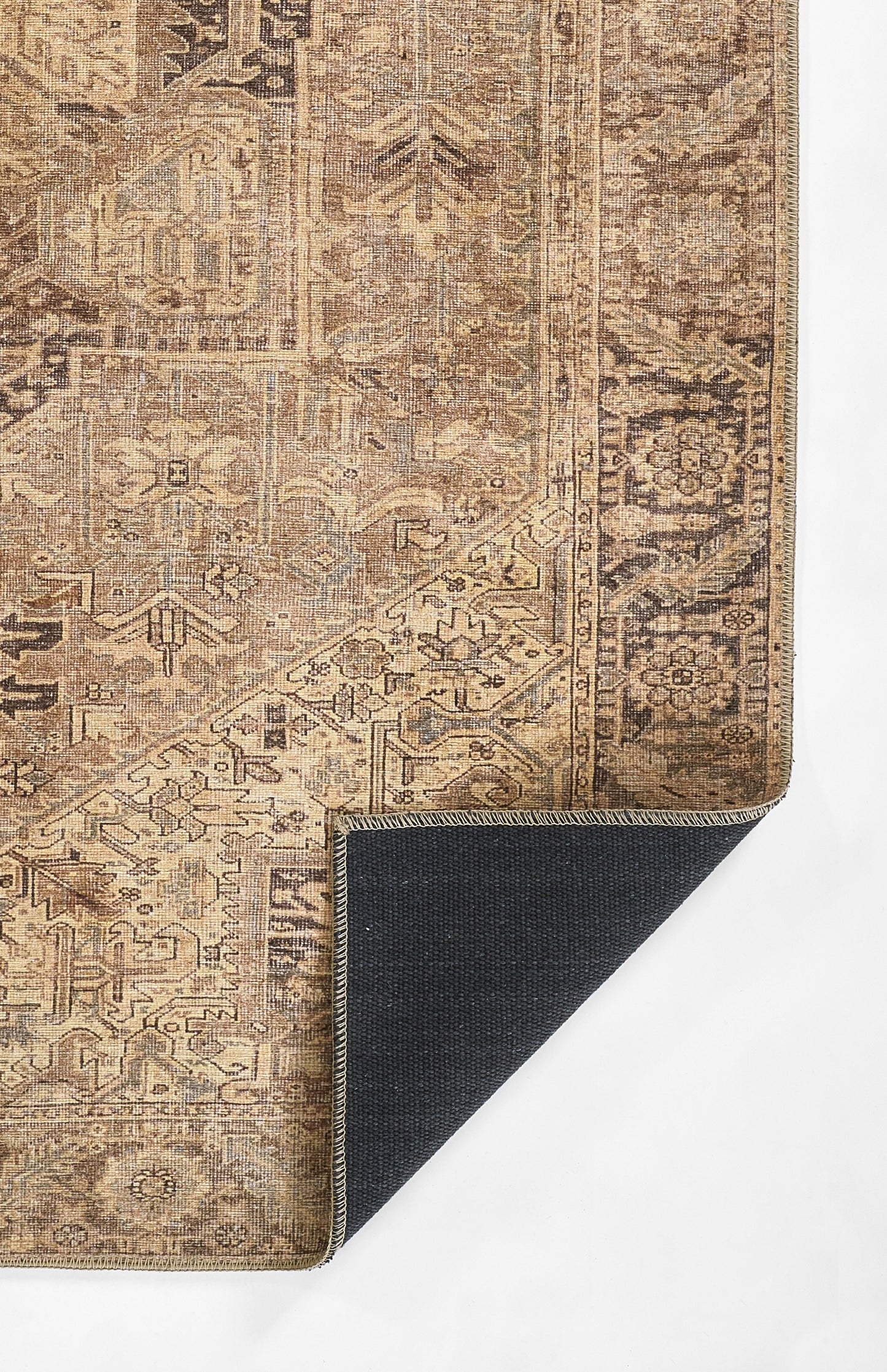 Distressed brown-beige oriental rug with ornate border; folded corner reveals dark backing.