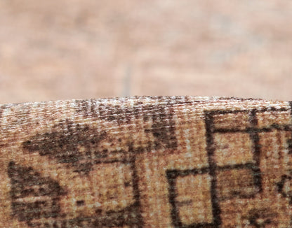 Close-up of brown geometric-patterned rug edge with plush pile and warm tones.