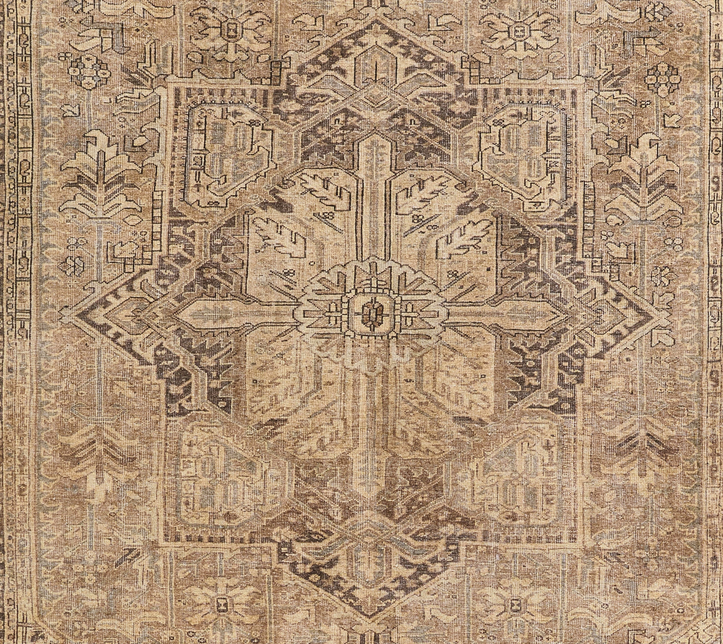 Rectangular vintage oriental rug in warm browns and beiges with a central medallion and intricate border.