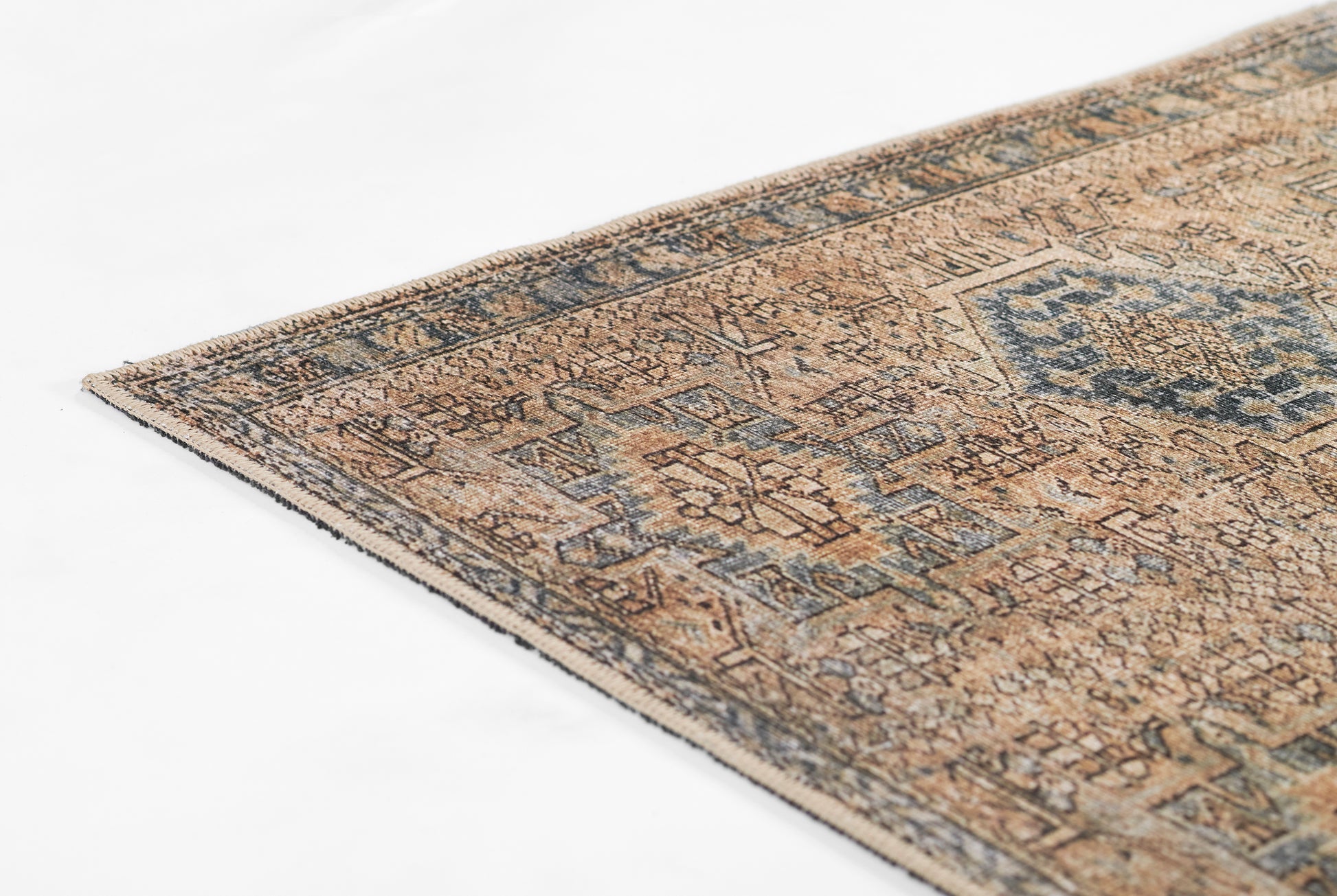 Beige oriental rug with blue geometric motifs and distressed finish, edged with a dark border.