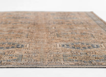 Rectangular distressed blue and tan oriental rug with geometric medallions, low-pile, fringed edges.
