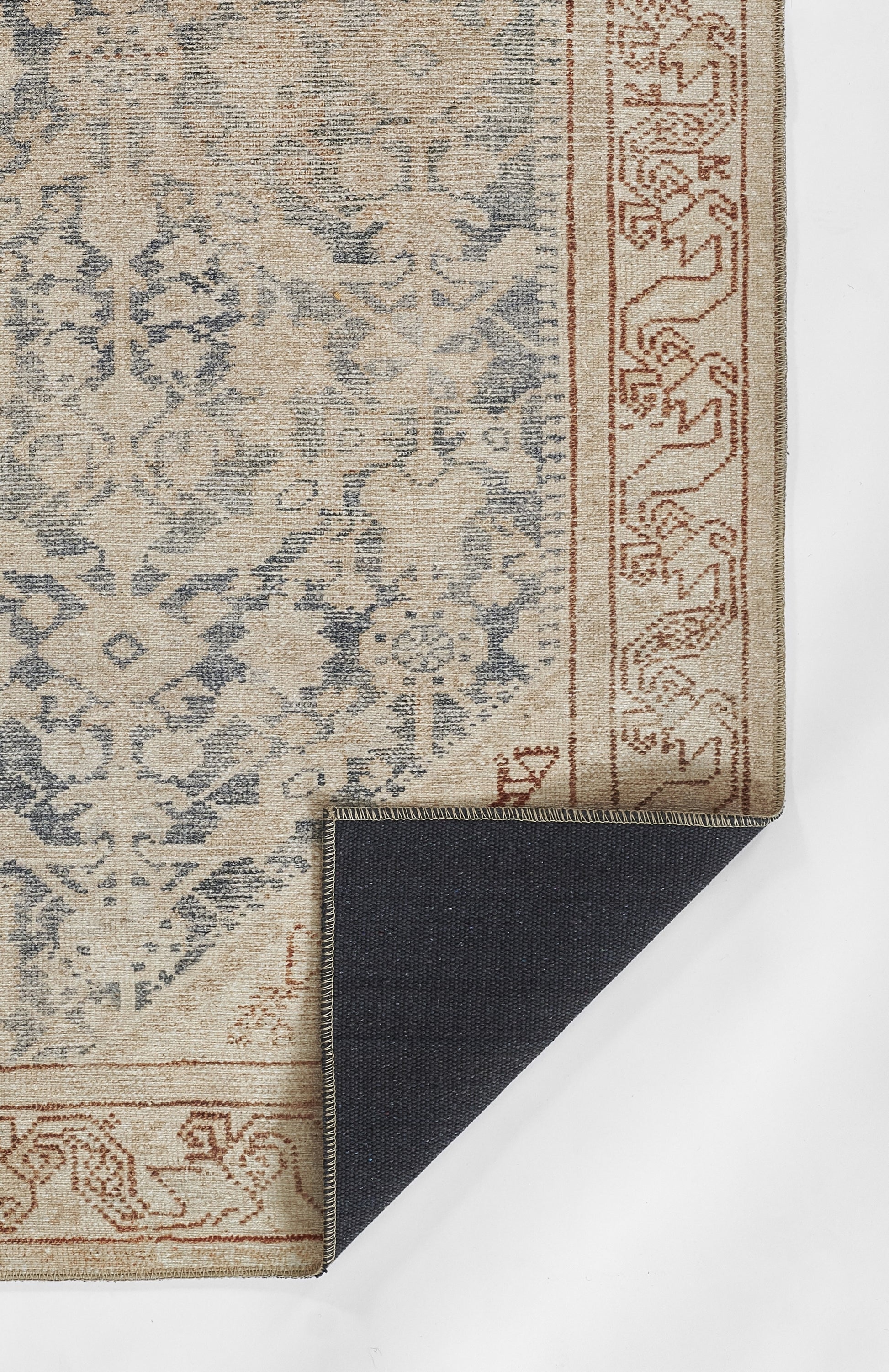Beige and blue ornamental area rug with floral medallion motif, rust border; folded navy reverse shows weave.