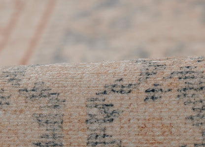 Close-up of beige woven rug edge with textured fibers and dark, script-like print.