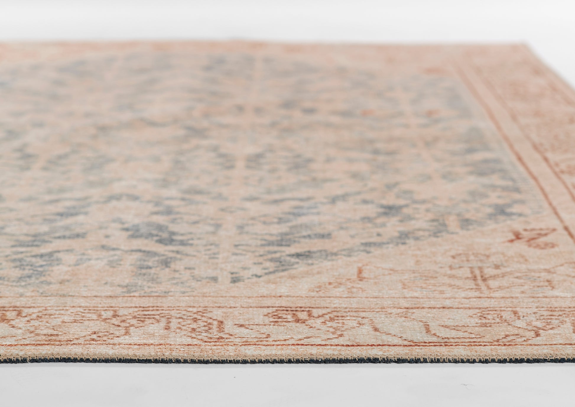 Rectangular vintage-style rug with pale blue distressed center and warm peach border.