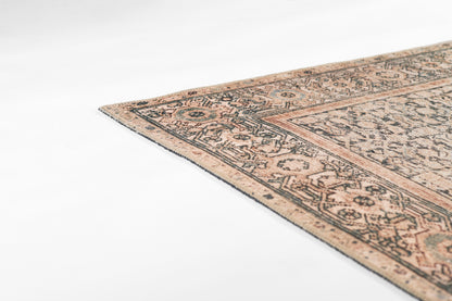 Rectangular wool oriental area rug in peach, ivory and blue with intricate border and distressed pattern.