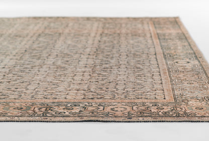 Rectangular oriental rug in warm peach and blue-gray tones with floral border, low-pile wool look.