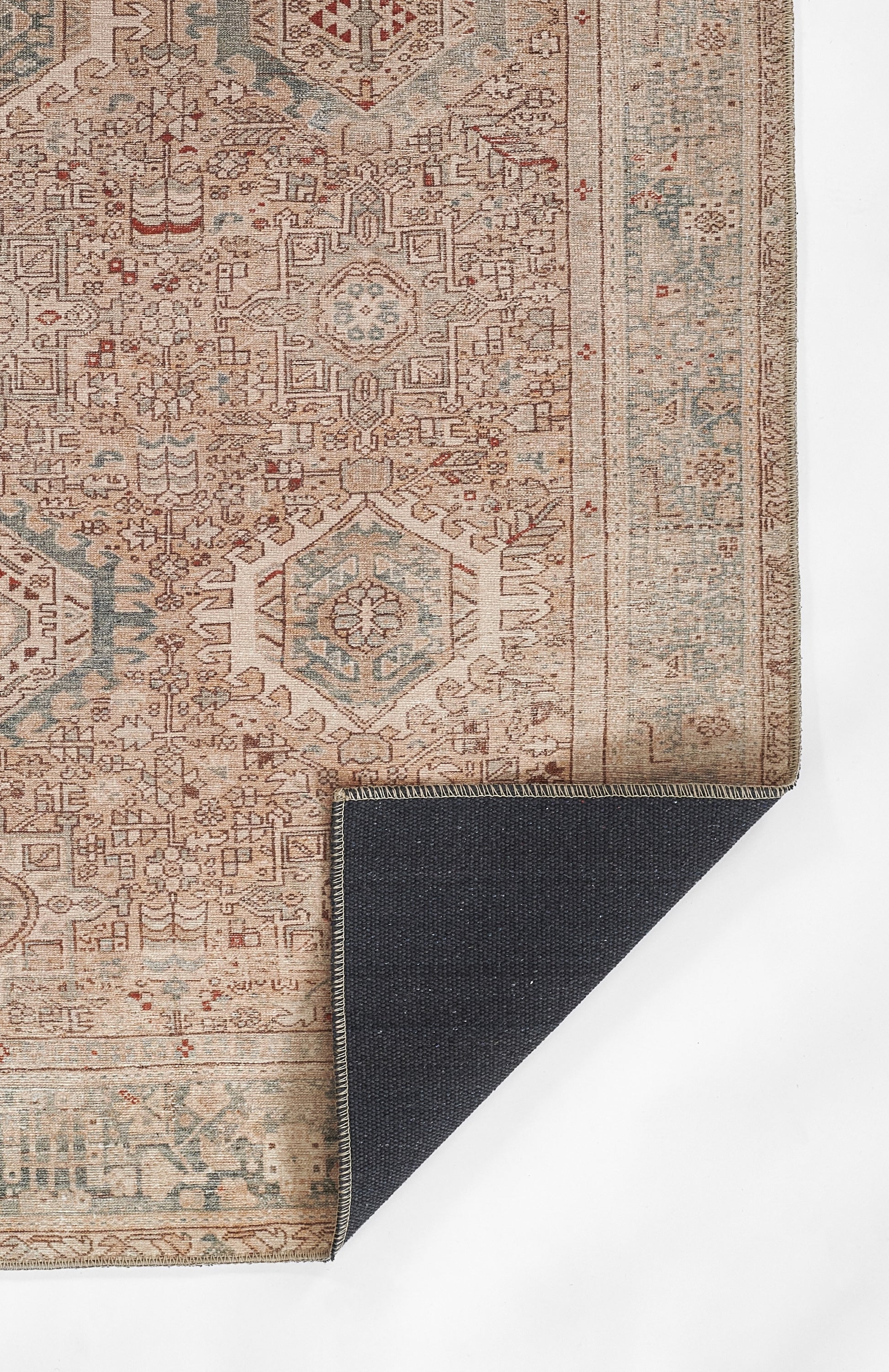 Oriental beige rug with blue and rust geometric medallions and detailed border; dark navy reverse corner folded.