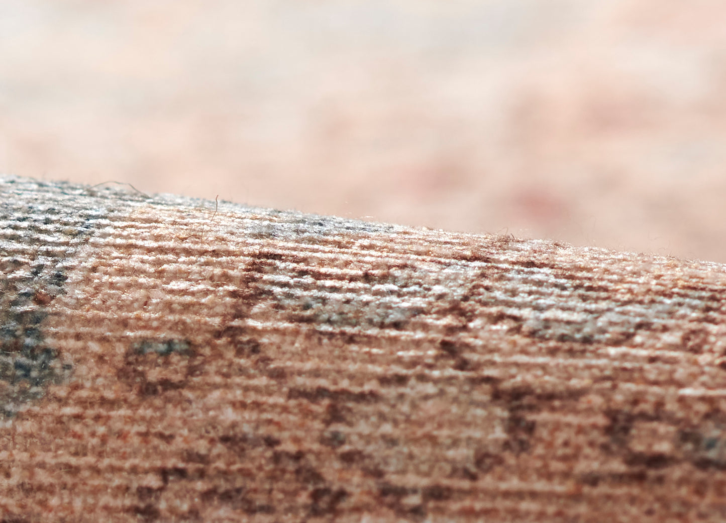 Macro shot of a flat, textured brown rock surface with tan and gray speckles.