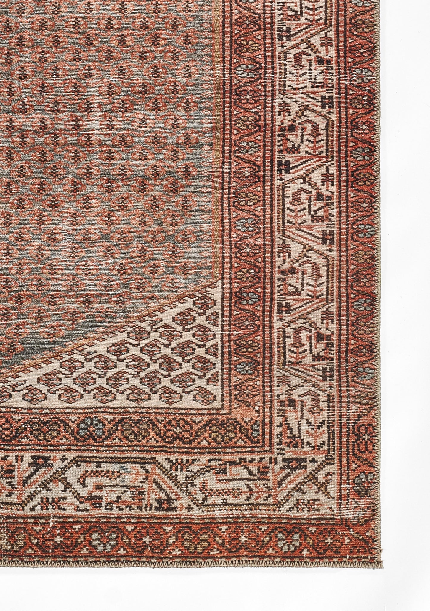 Persian-style area rug with red, ivory and blue hues, intricate geometric borders, floral motifs and fringe.