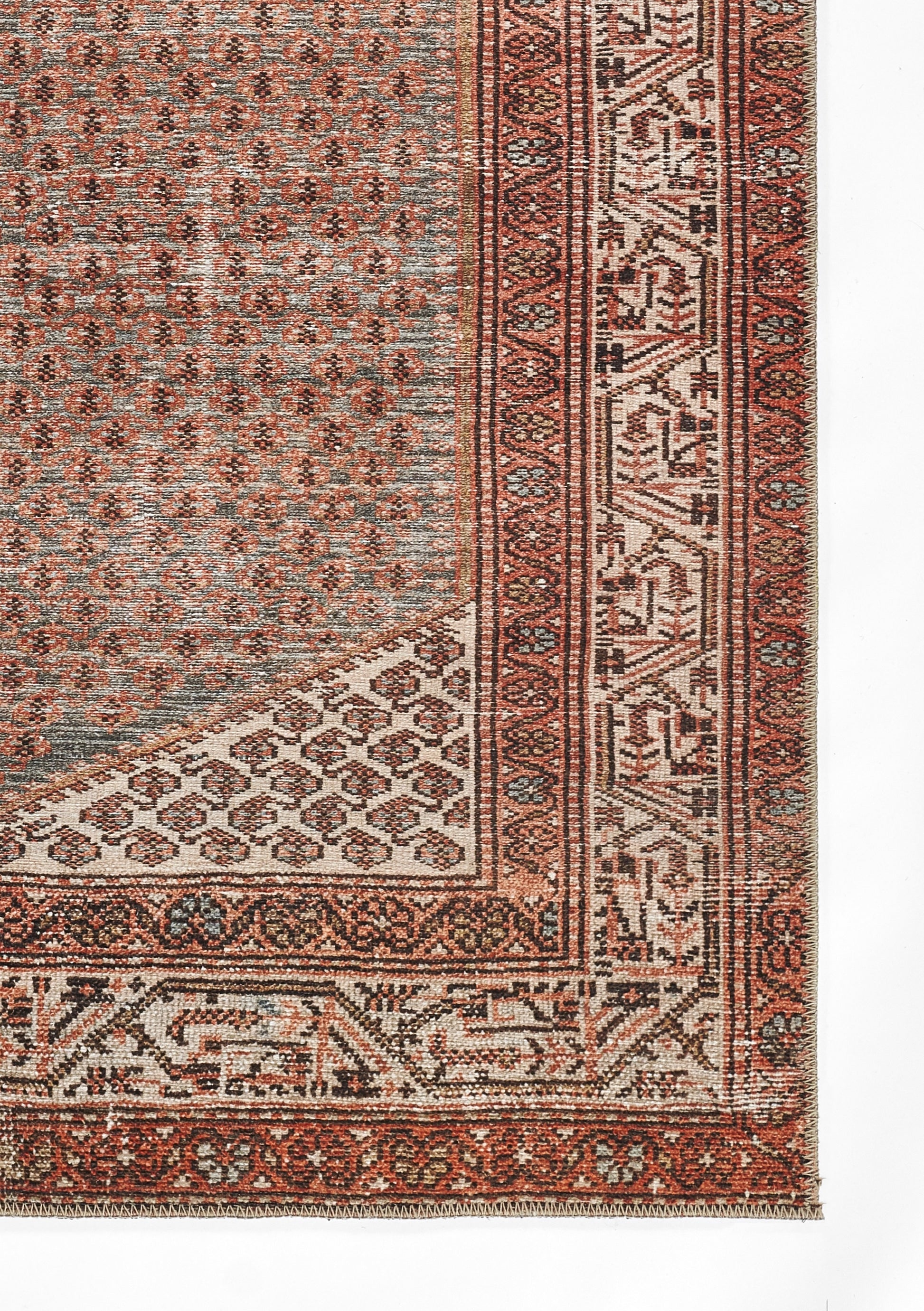Persian-style area rug with red, ivory and blue hues, intricate geometric borders, floral motifs and fringe.
