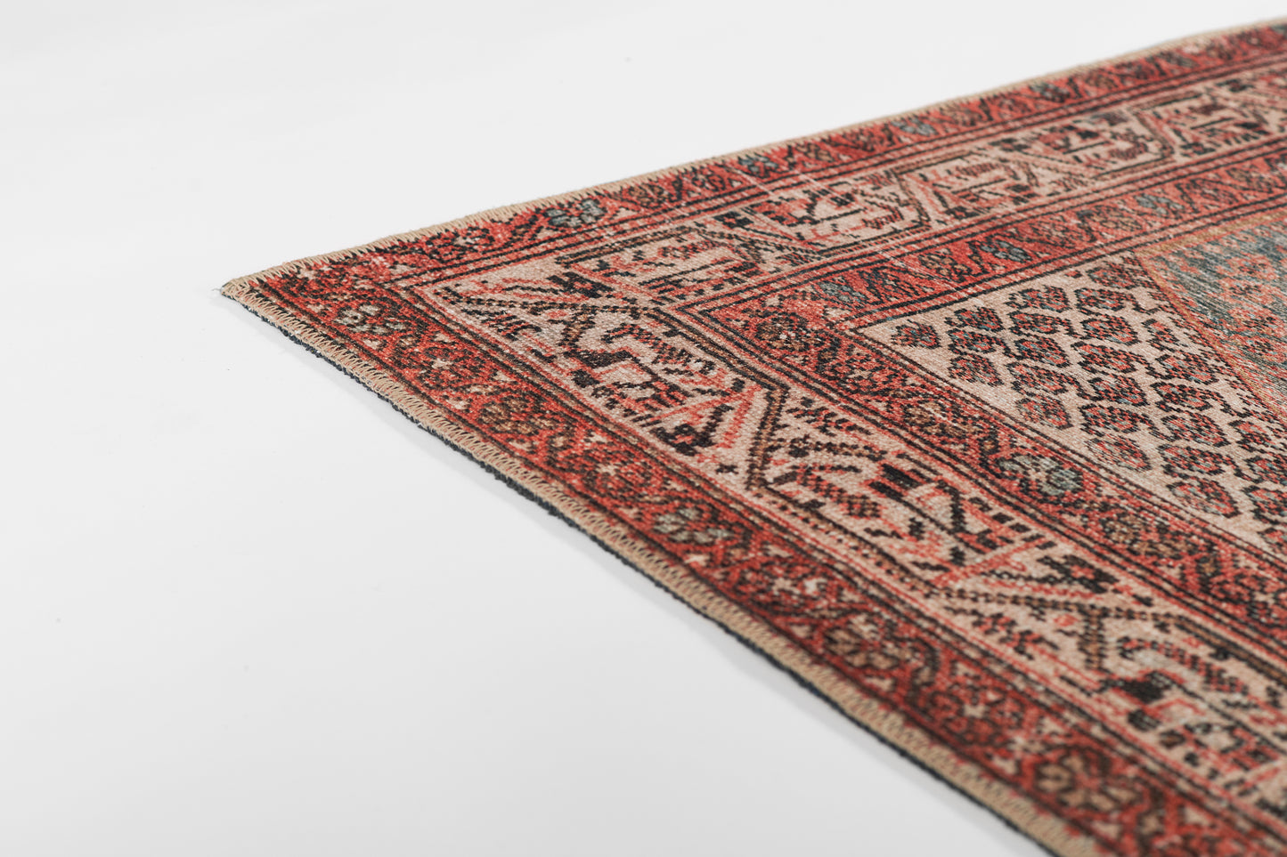 Red, ivory and black geometric Oriental rug with diamond motifs and fringed border.