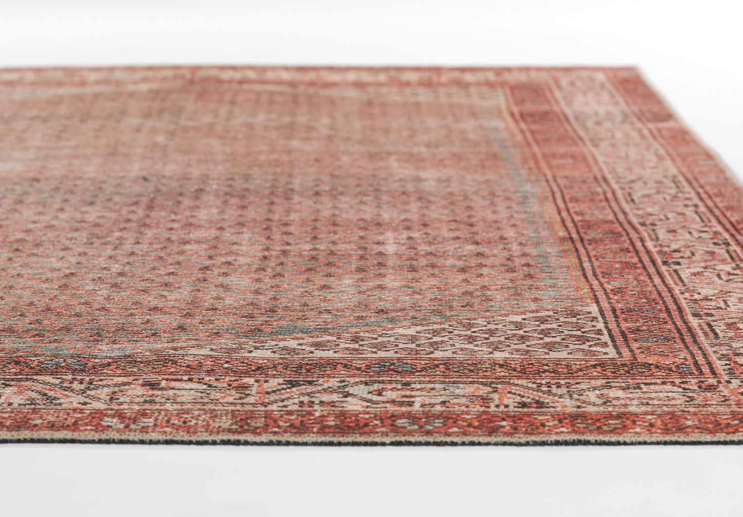 Rust-red Persian-style rug with intricate beige borders and geometric motifs; vintage distressed look, rectangular shape.