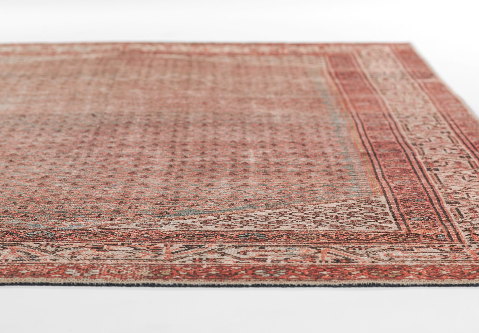 Rust-red Persian-style rug with intricate beige borders and geometric motifs; vintage distressed look, rectangular shape.