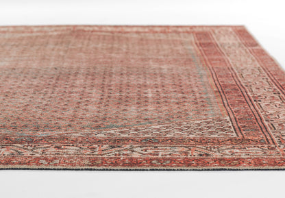 Rust-red Persian-style rug with intricate beige borders and geometric motifs; vintage distressed look, rectangular shape.