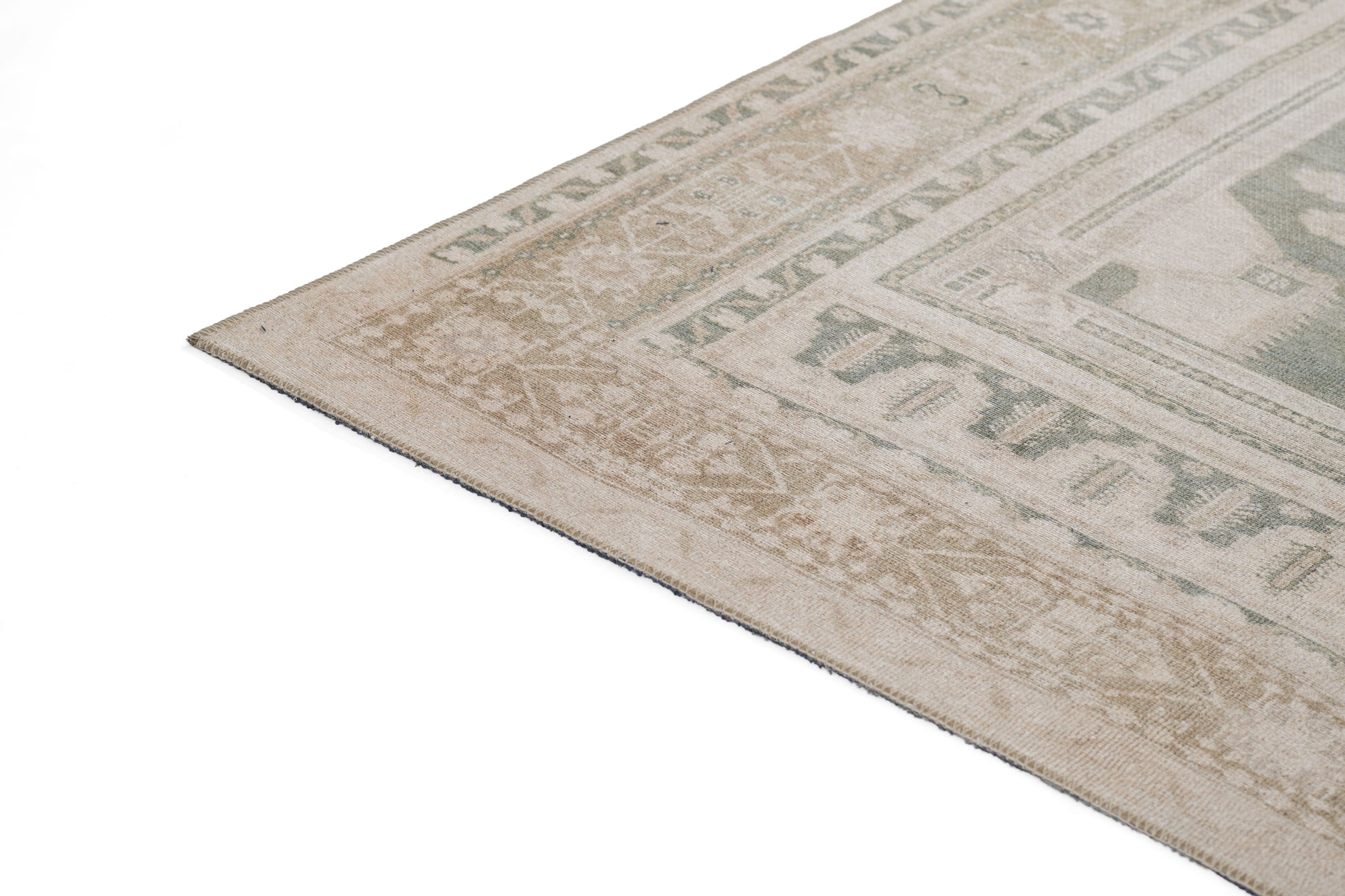 Beige-gray oriental area rug with decorative border; corner edge visible on white background.