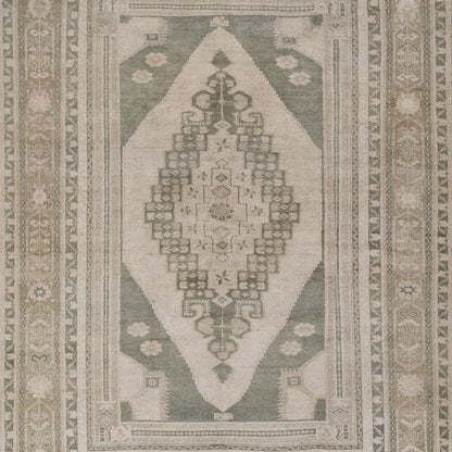 Rectangular runner rug in sage green and ivory with a central diamond medallion and geometric borders; kilim-inspired decor.