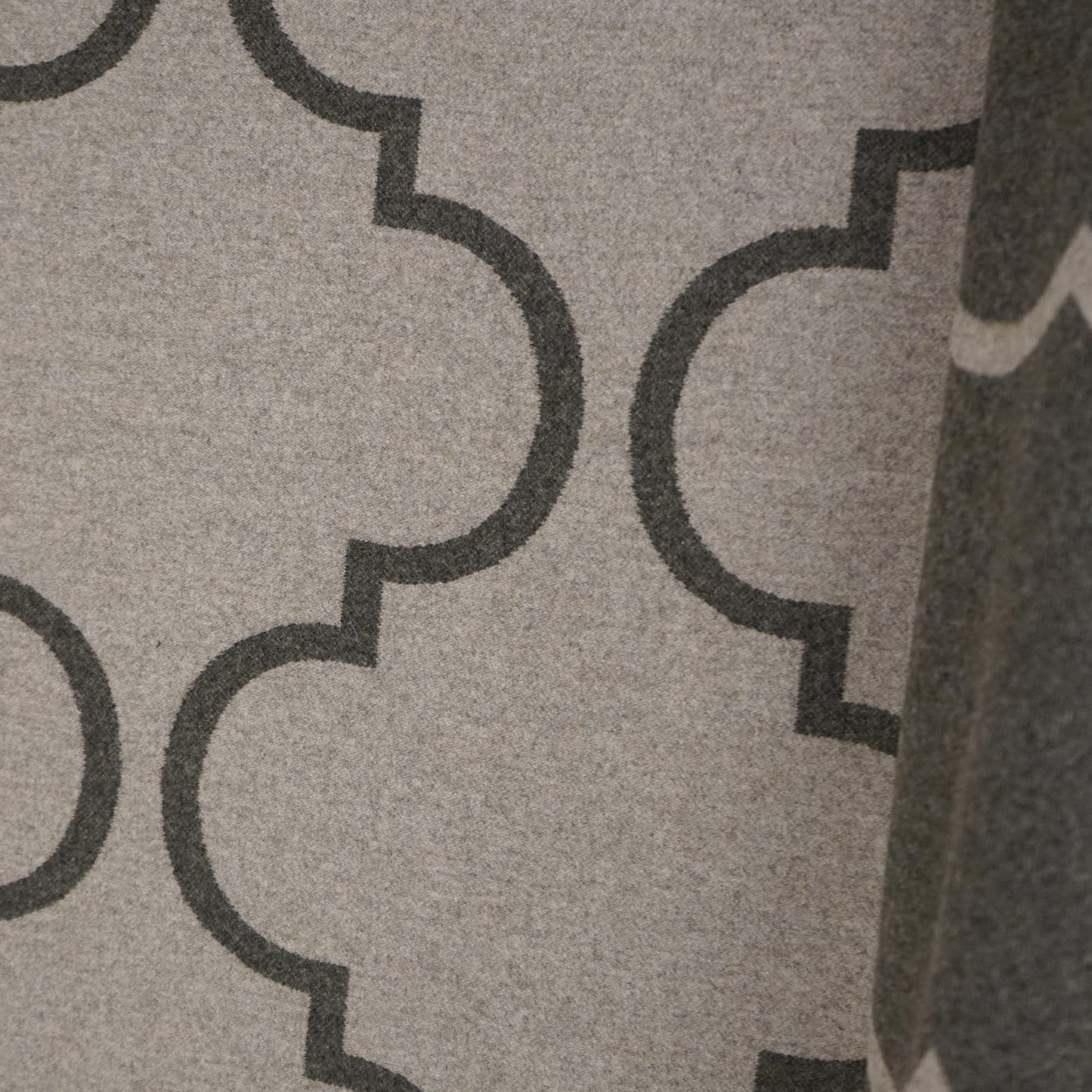 Beige woven upholstery fabric with dark gray quatrefoil geometric pattern.
