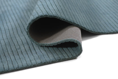 Teal corduroy fabric swatch with a rolled edge, ribbed wale texture and soft backing—great for upholstery or crafts.