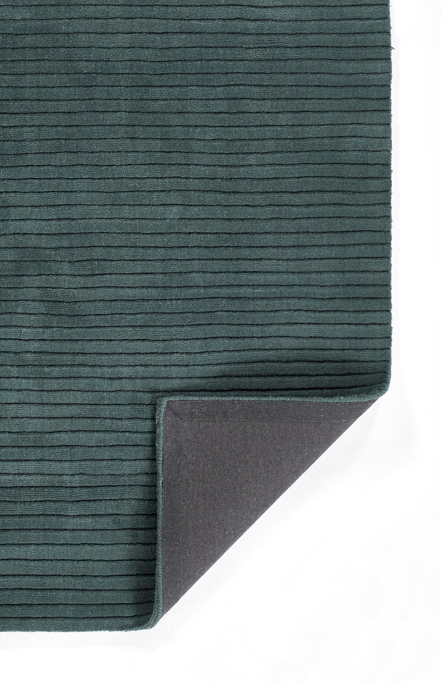 Teal ribbed rug mat with soft velvety texture and gray non-slip backing; rectangular with folded corner.