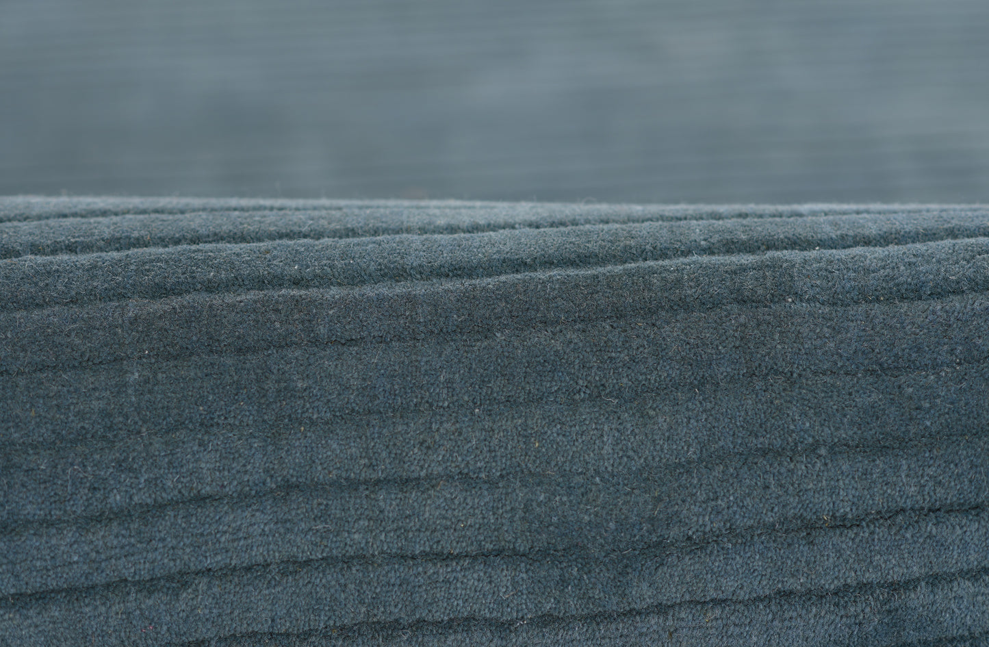 Dark blue fleece fabric close-up with soft, fuzzy texture and layered folds.