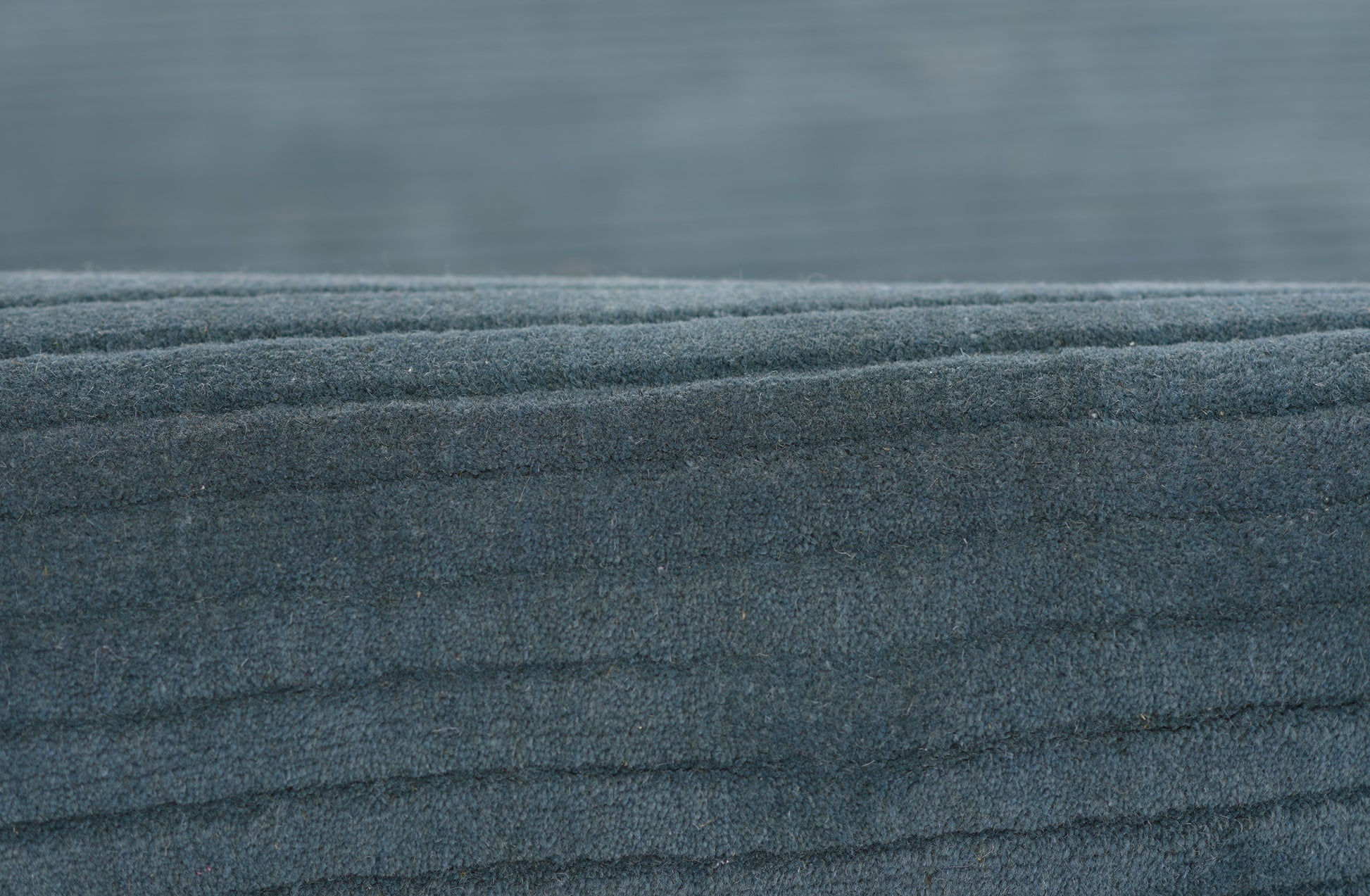 Dark blue fleece fabric close-up with soft, fuzzy texture and layered folds.