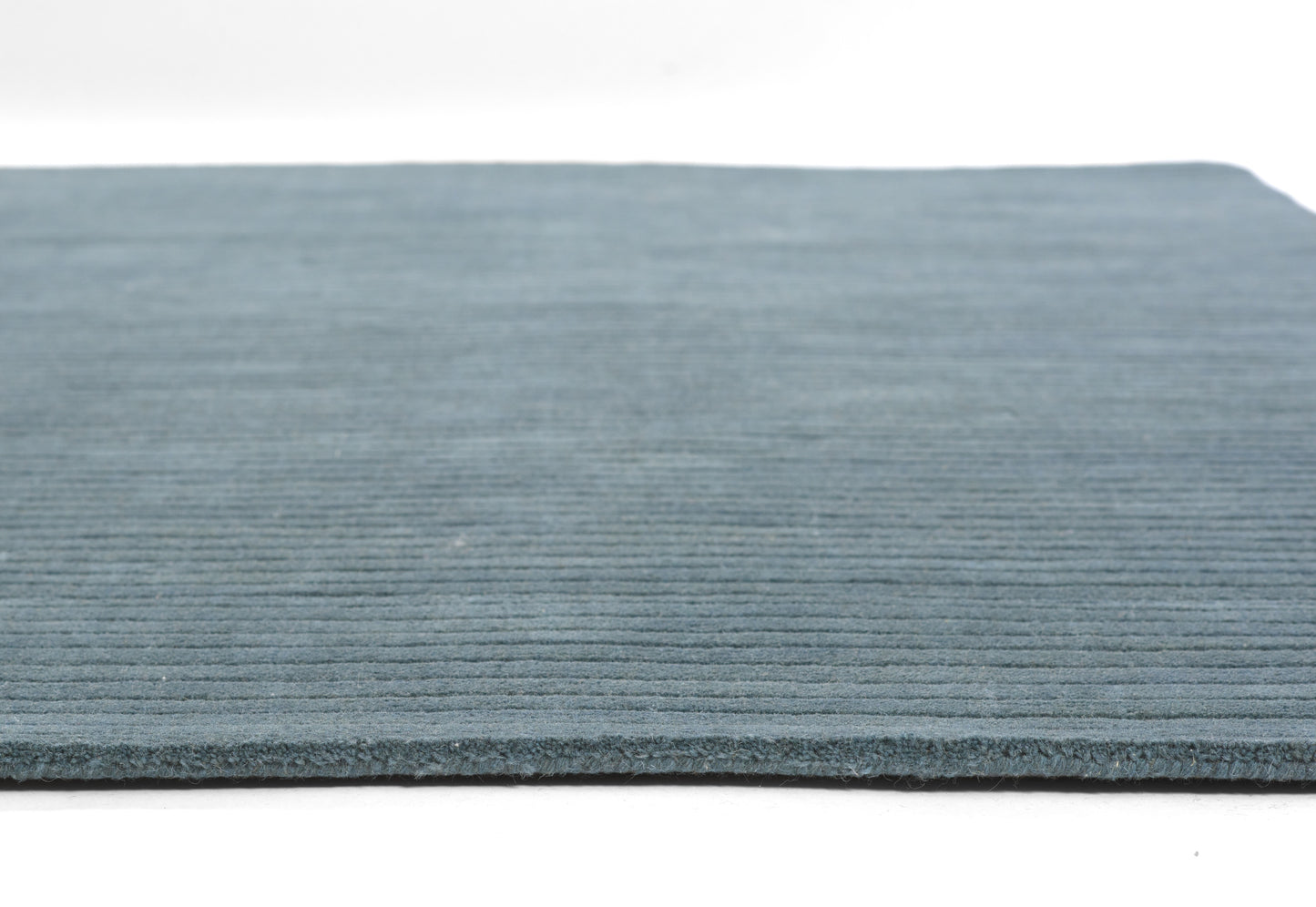 Blue ribbed rug with horizontal lines, low-pile texture, edge visible; casual, modern area rug.
