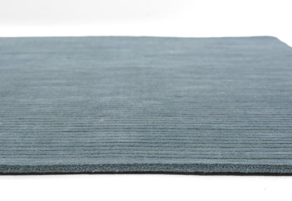 Blue ribbed rug with horizontal lines, low-pile texture, edge visible; casual, modern area rug.