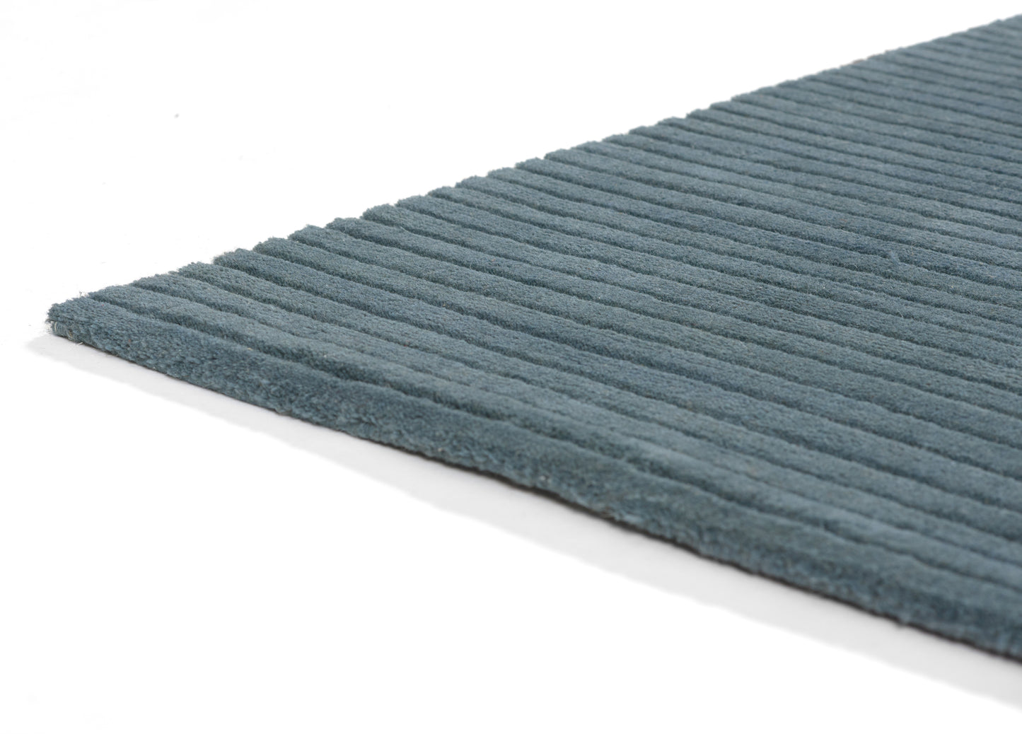 Blue ribbed microfiber bath rug with raised stripes; soft, rectangular bathroom mat.