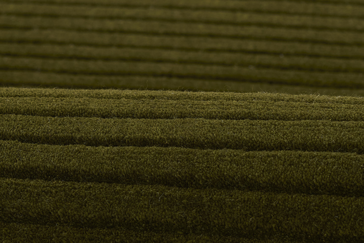Olive green ribbed textile with parallel horizontal ridges and soft texture.