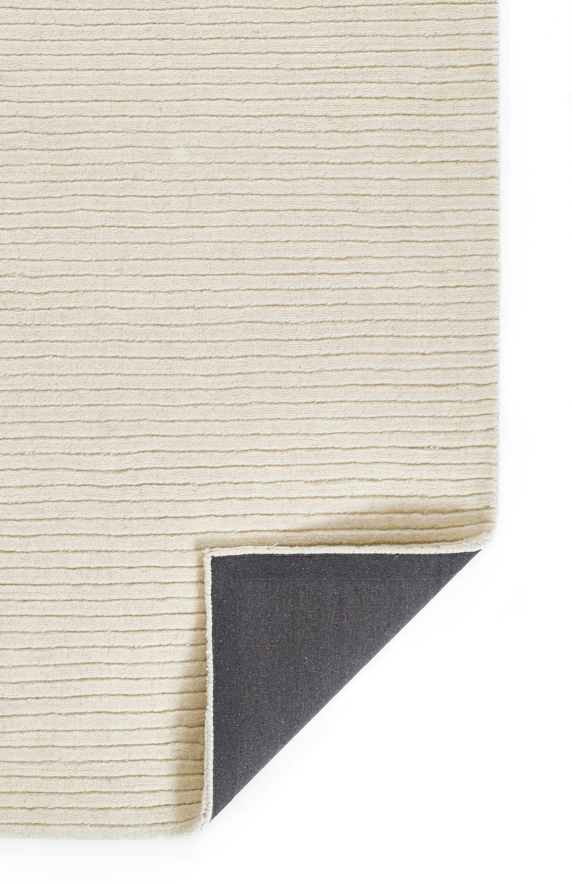 Beige ribbed area rug with horizontal stripes; corner folded to reveal charcoal underside.