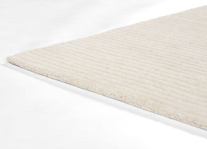 Cream ribbed area rug with soft, low-pile texture and horizontal stripes.