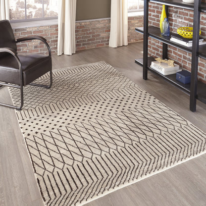 Natural beige area rug with black geometric chevron pattern in a modern industrial living room.