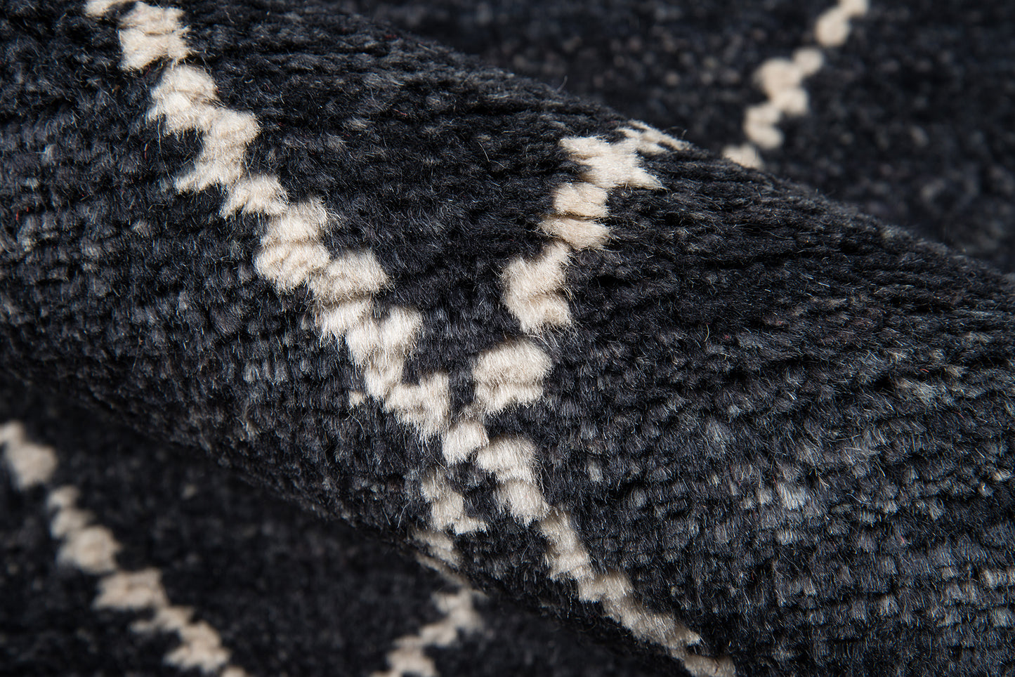 Dark navy shag rug with white chevron zigzag pattern; plush textured weave.