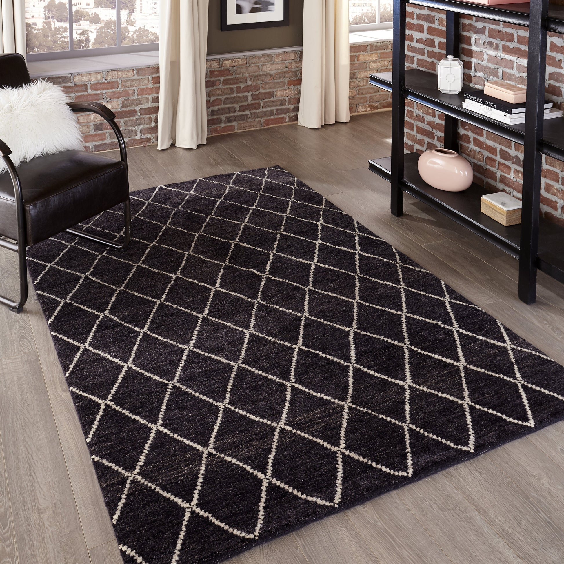 Charcoal shag rug with white diamond lattice in a modern living room with brick wall, black chair, and metal shelf.