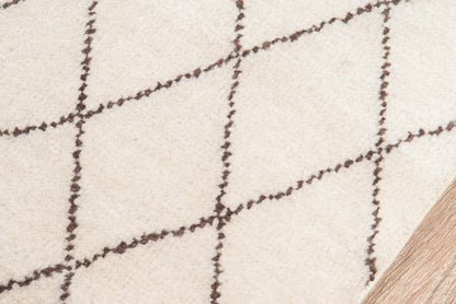 Beige rug with dark brown diagonal grid/diamond pattern, soft texture, on light wood floor.