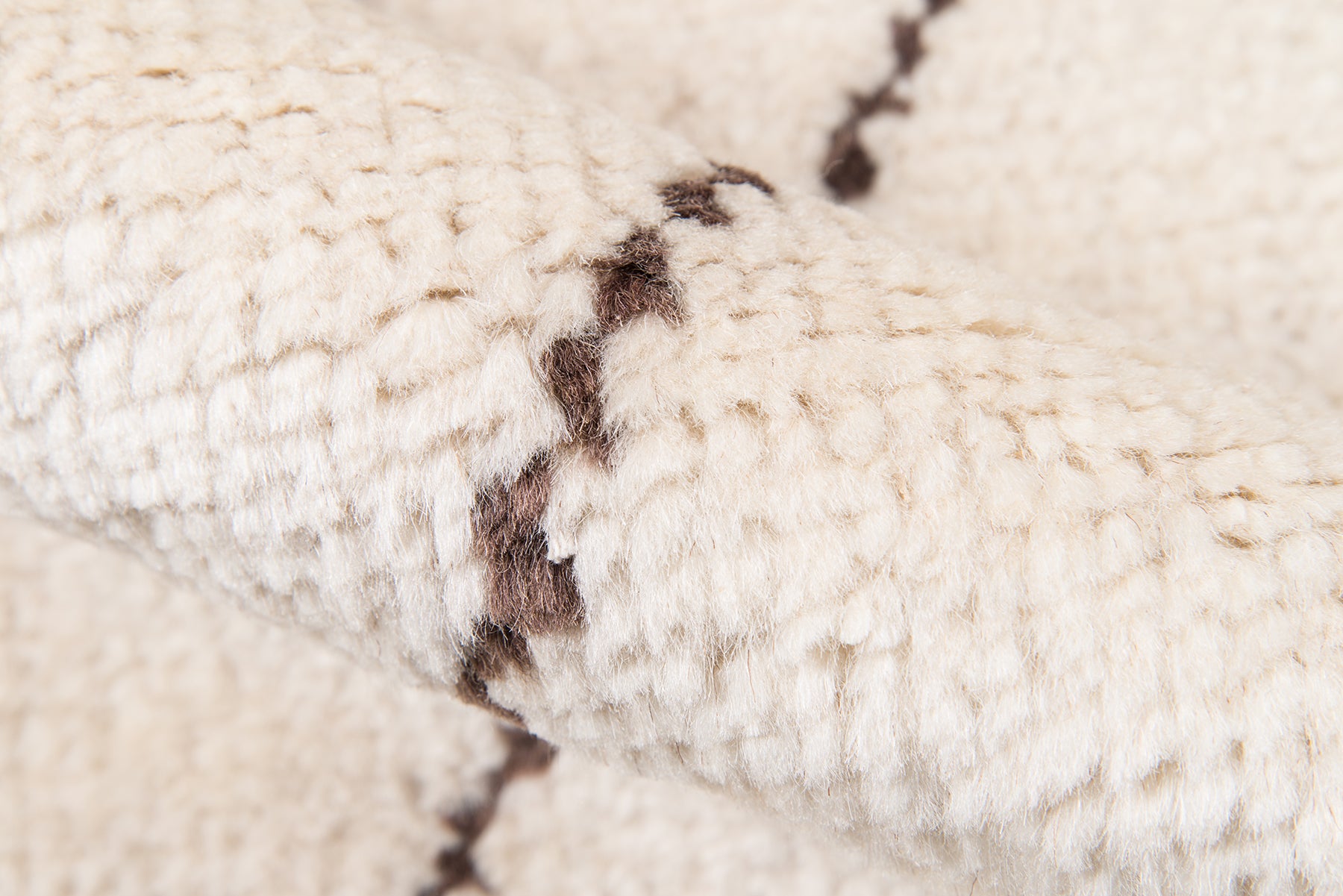 Cream chunky knit scarf with dark brown seam stitches, soft cozy textile.