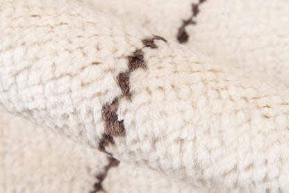 Cream chunky knit scarf with dark brown seam stitches, soft cozy textile.