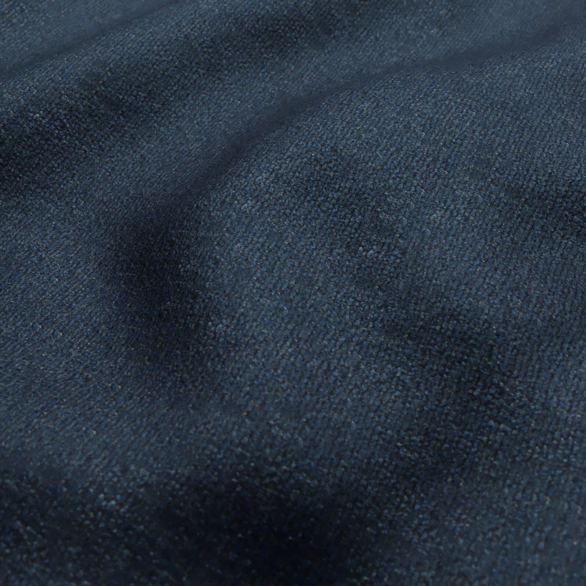 Close-up of dark blue boucle fabric texture with subtle creases.