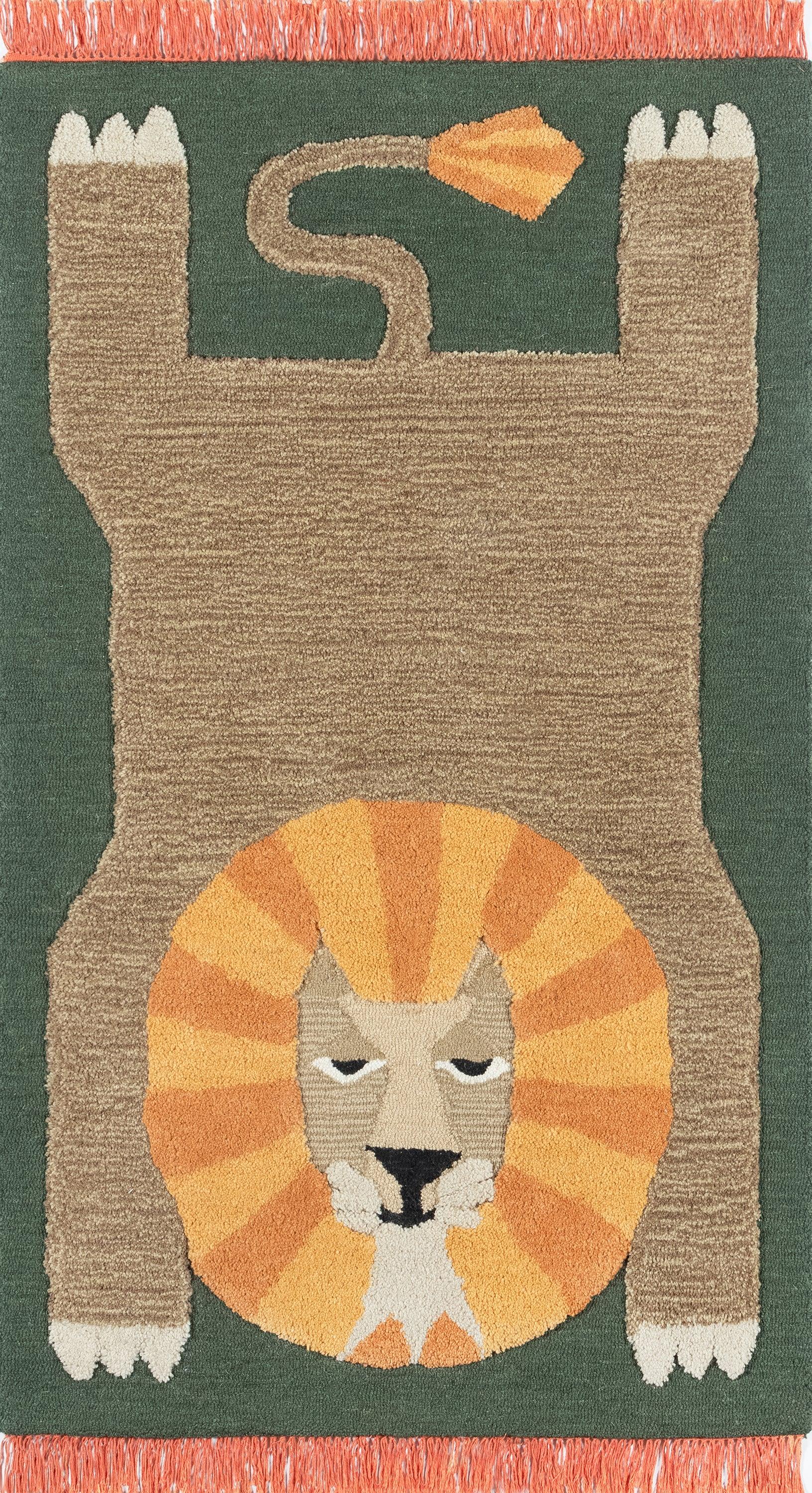 Brown cat-shaped rug on green field with an orange lion mane around a beige face, white paws, and orange fringe.