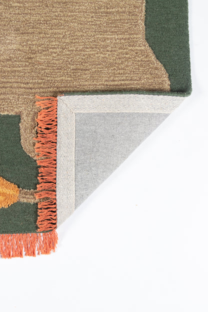 Woven geometric area rug in olive green and tan with orange fringe; folded corner shows gray backing.