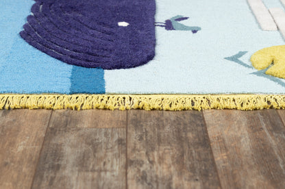 Blue rug with purple looped pile accent and yellow fringe along edge on dark wooden floor.