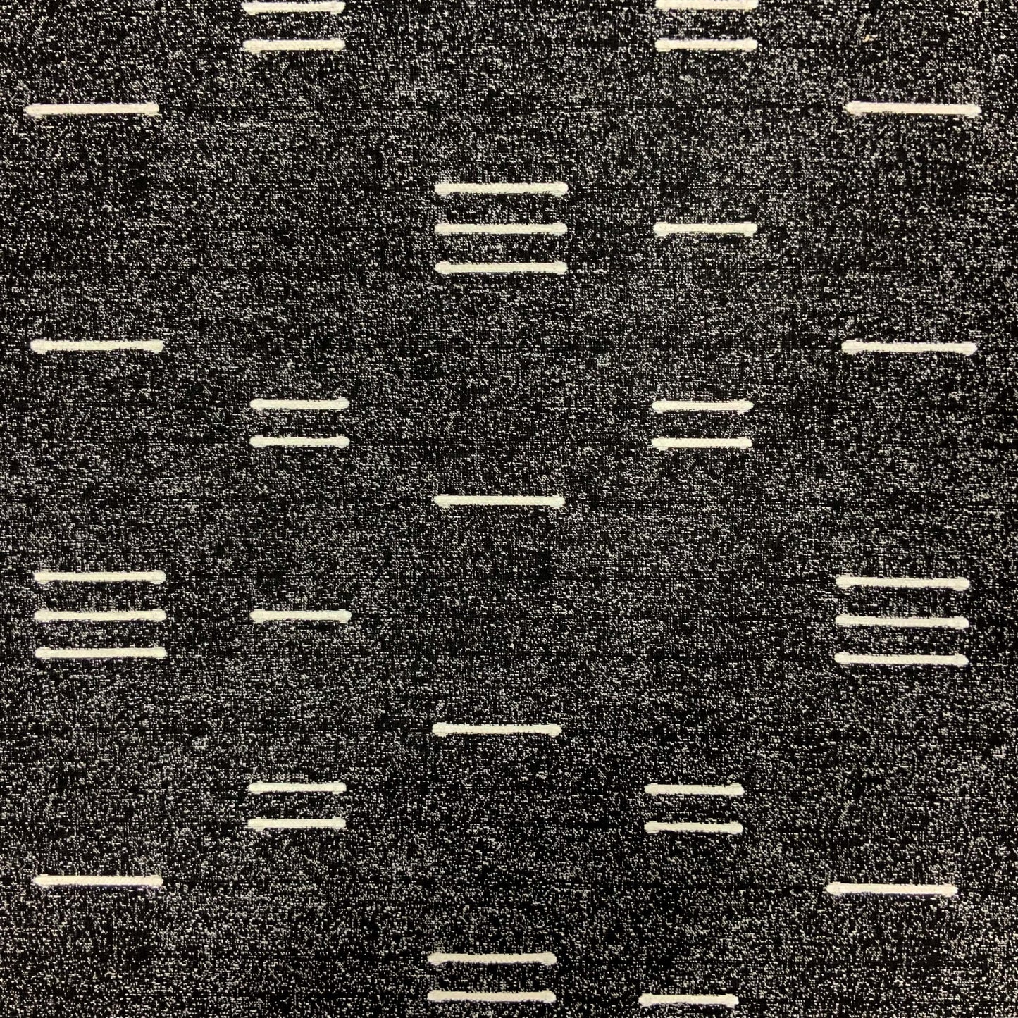 Dark charcoal woven jacquard fabric with white dashed stripes in a minimalist geometric pattern.