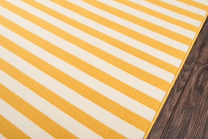 Rectangular yellow and white striped woven cotton rug on dark wood floor.