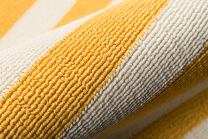 Close-up of yellow and white striped rug with plush looped pile and woven texture.