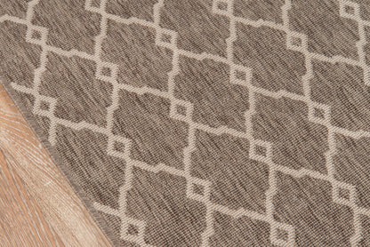 Taupe rug with cream geometric lattice pattern and woven texture on light wood floor.