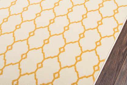 Cream area rug with bright yellow geometric lattice pattern, shown on dark wood flooring.